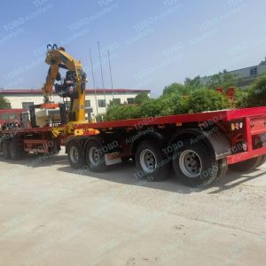 Disheveled flatbed crane semi-trailer